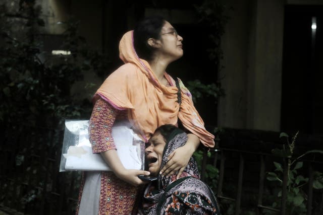 <p>File. A Bangladeshi woman consoles her mother as she weeps after receiving the body of her son, who was shot during a clash between protesters and police in Dhaka </p>