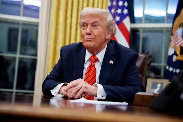 <p>Donald Trump reacts to a question from a reporter in the Oval Office. Trump and his family has benefitted financially following his return to the White House including raising $80 million for his library</p>