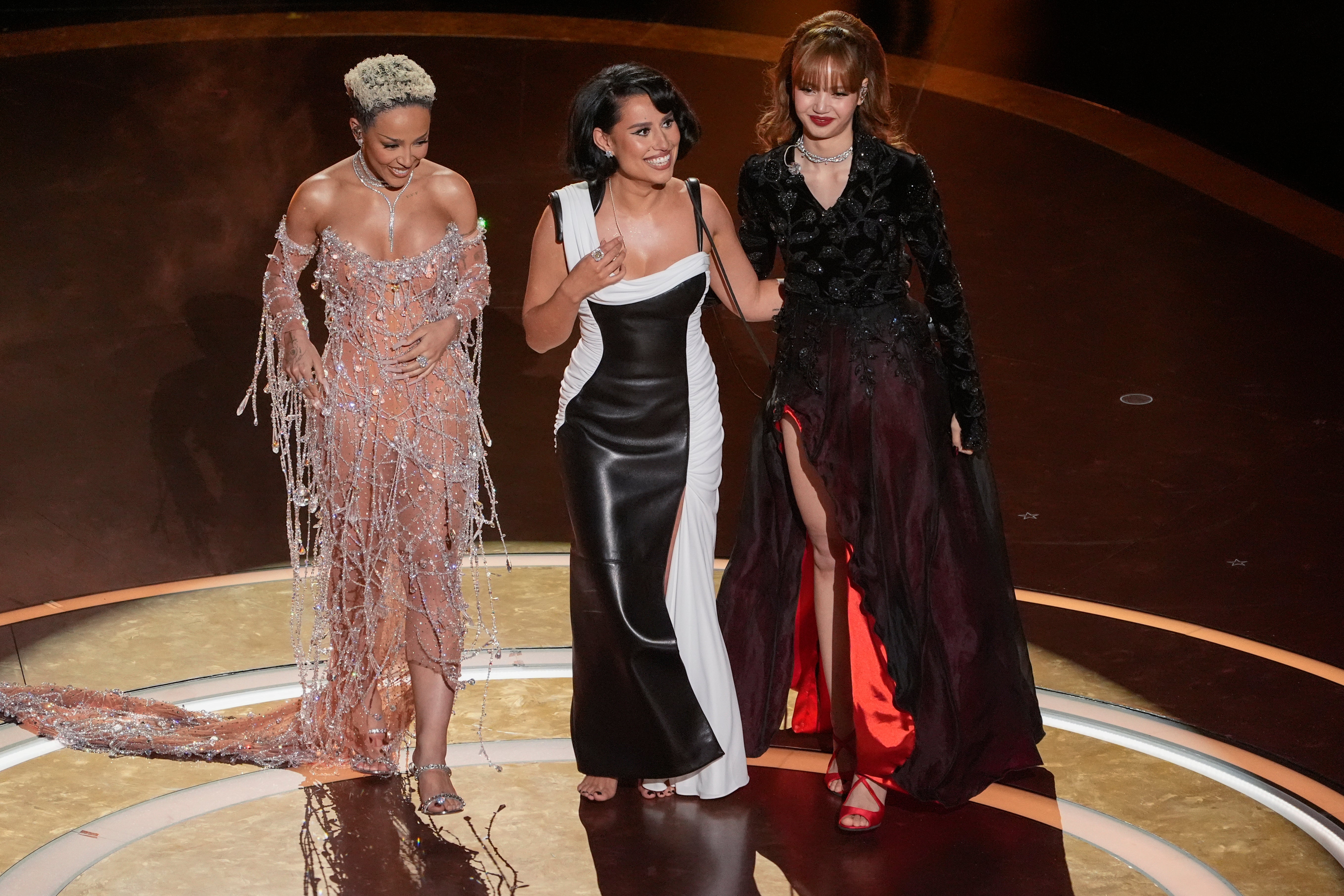 L-R: Doja Cat, RAYE and Lisa onstage at the 2025 Oscars