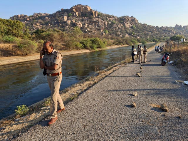 <p>A police officer speaks on his mobile phone at the scene as they investigate an attack in Koppal district of southern state of Karnataka, India</p>