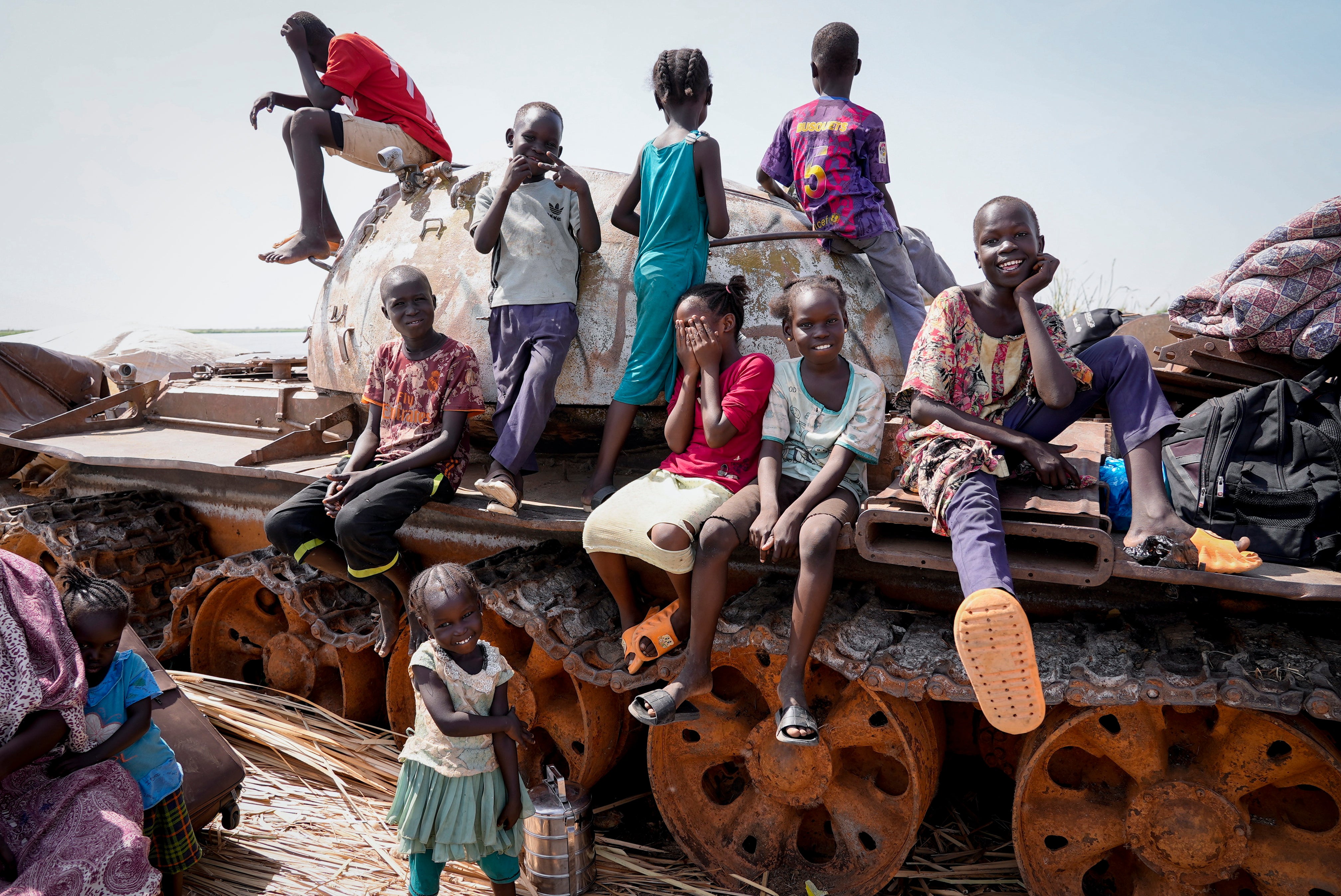 Children sit and play on the remains of a tank, at the river port in Renk, South Sudan on May 17, 2023