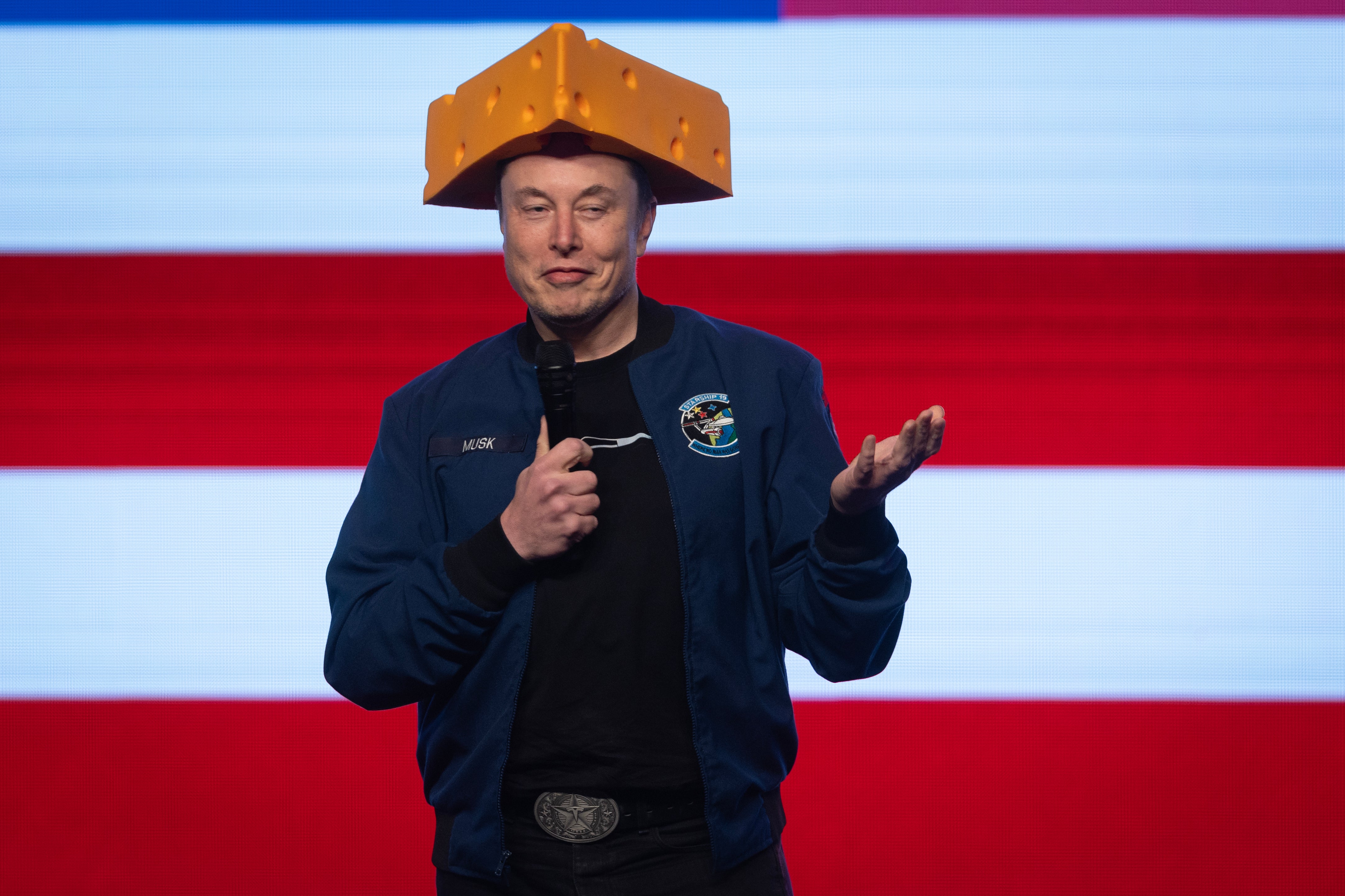 Elon Musk wears a Cheesehead hat as he speaks during a town hall in Green Bay, Wisconsin on March 30, 2025