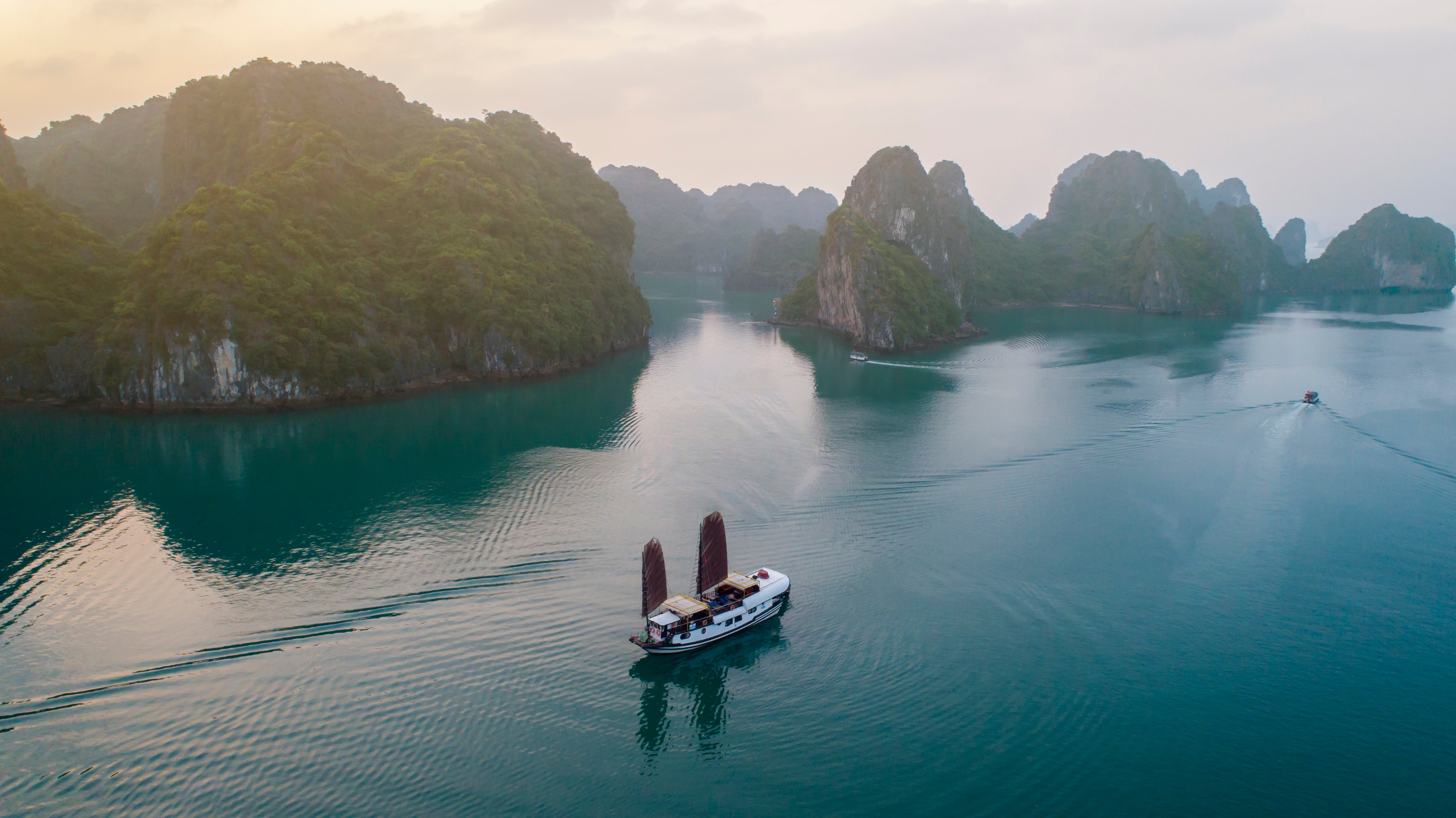 Board a traditional boat to sail through picturesque Bai Tu Long Bay