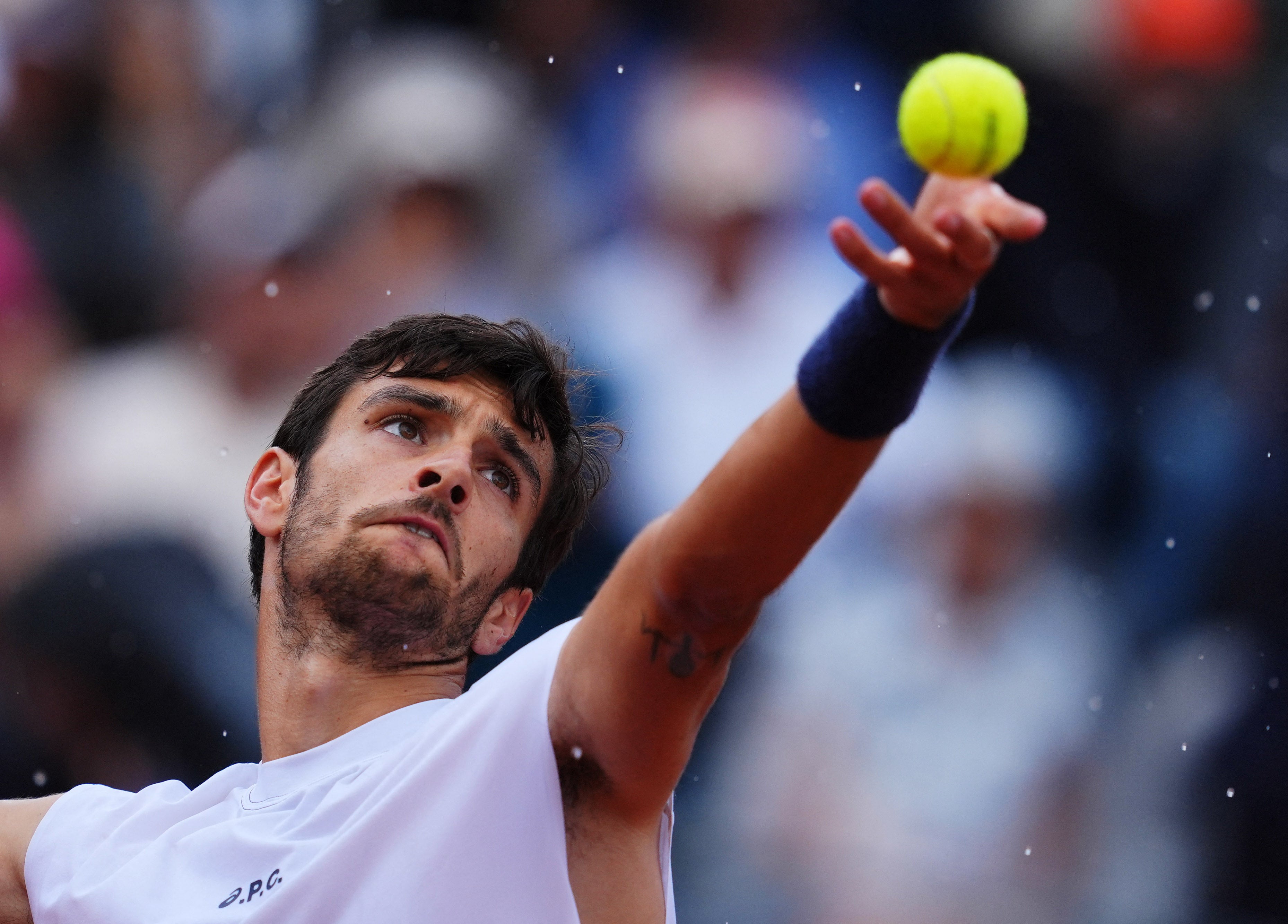 The rain falls as Lorenzo Musetti serves in the last-16