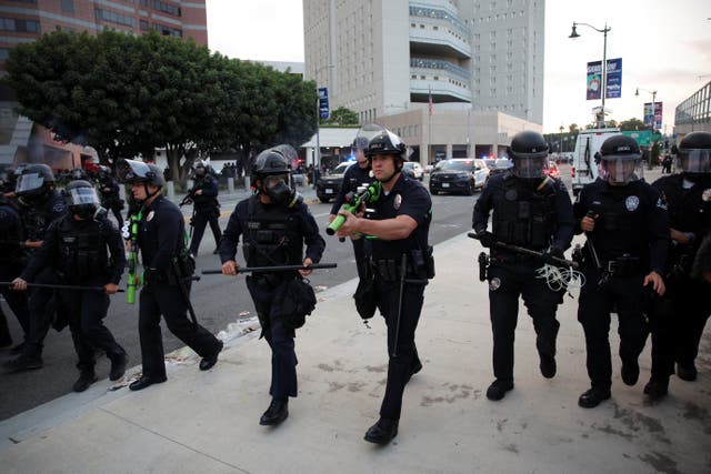 <p>Police take positions as they clash with protesters gathered around the Los Angeles Federal Building following multiple detentions by Immigration and Customs Enforcement (ICE), in downtown Los Angeles, California</p>