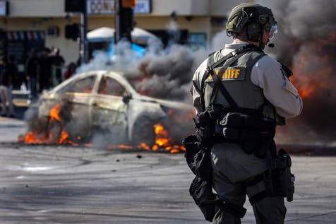 <p>Smoke rises from a burning car on Atlantic Boulevard during a standoff by protesters and law enforcement, LA, California, US, June 7, 2025</p>